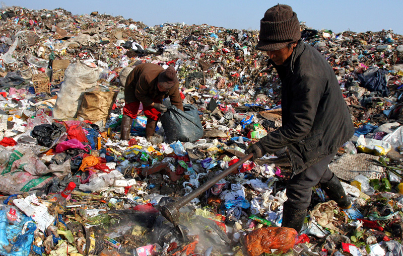 Image of family searching through garbage in landfill